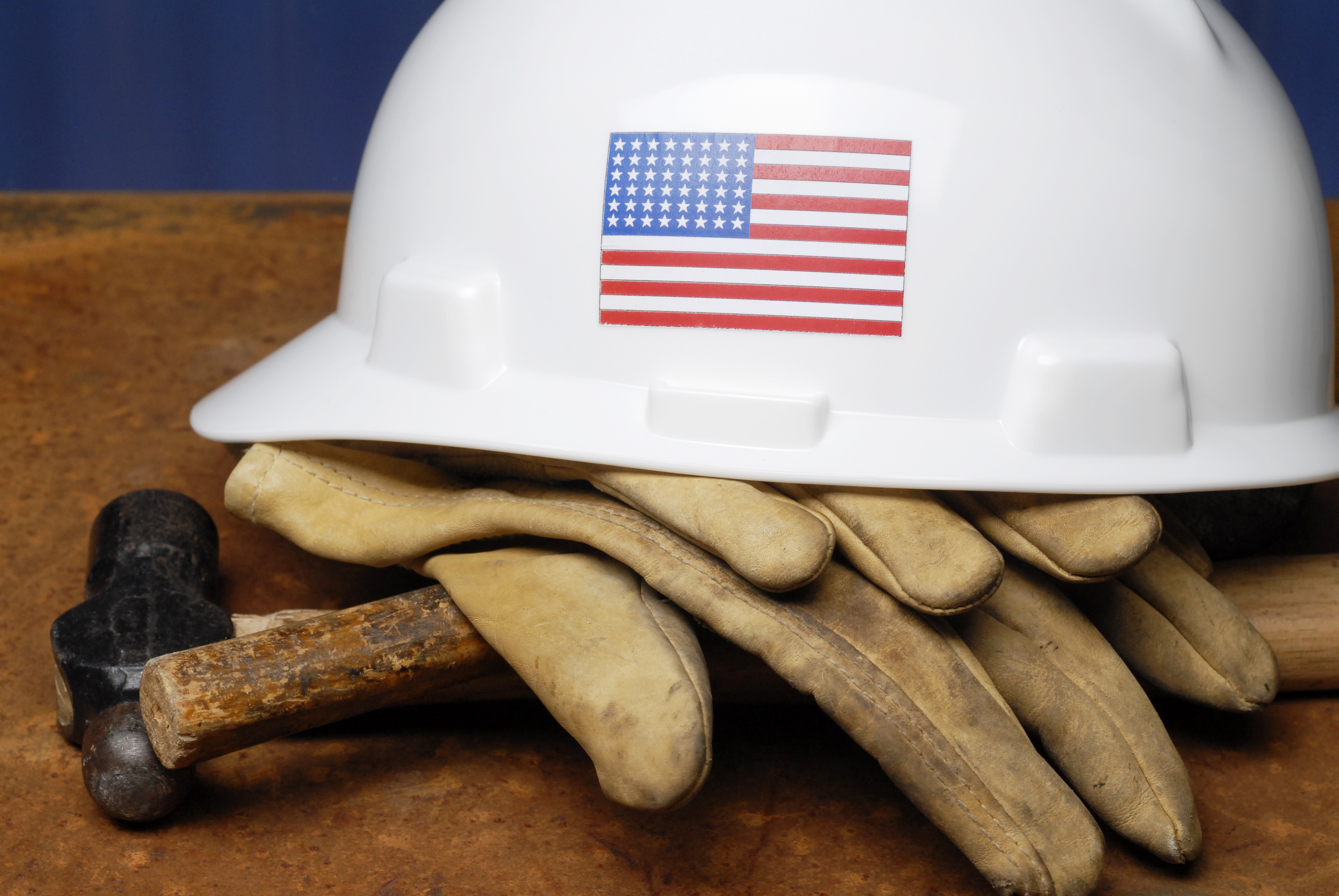 Stock Photograph of hard hat with U.S. flag and gloves.